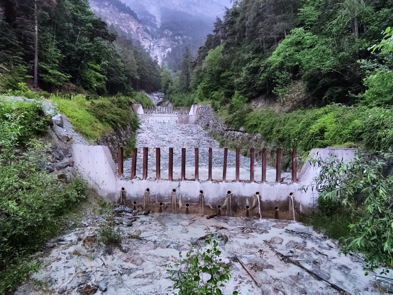 Obra de control con rejilla metálica en un canal de montaña