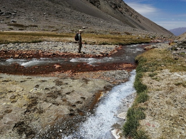 Profesional junto a un arroyo de montaña